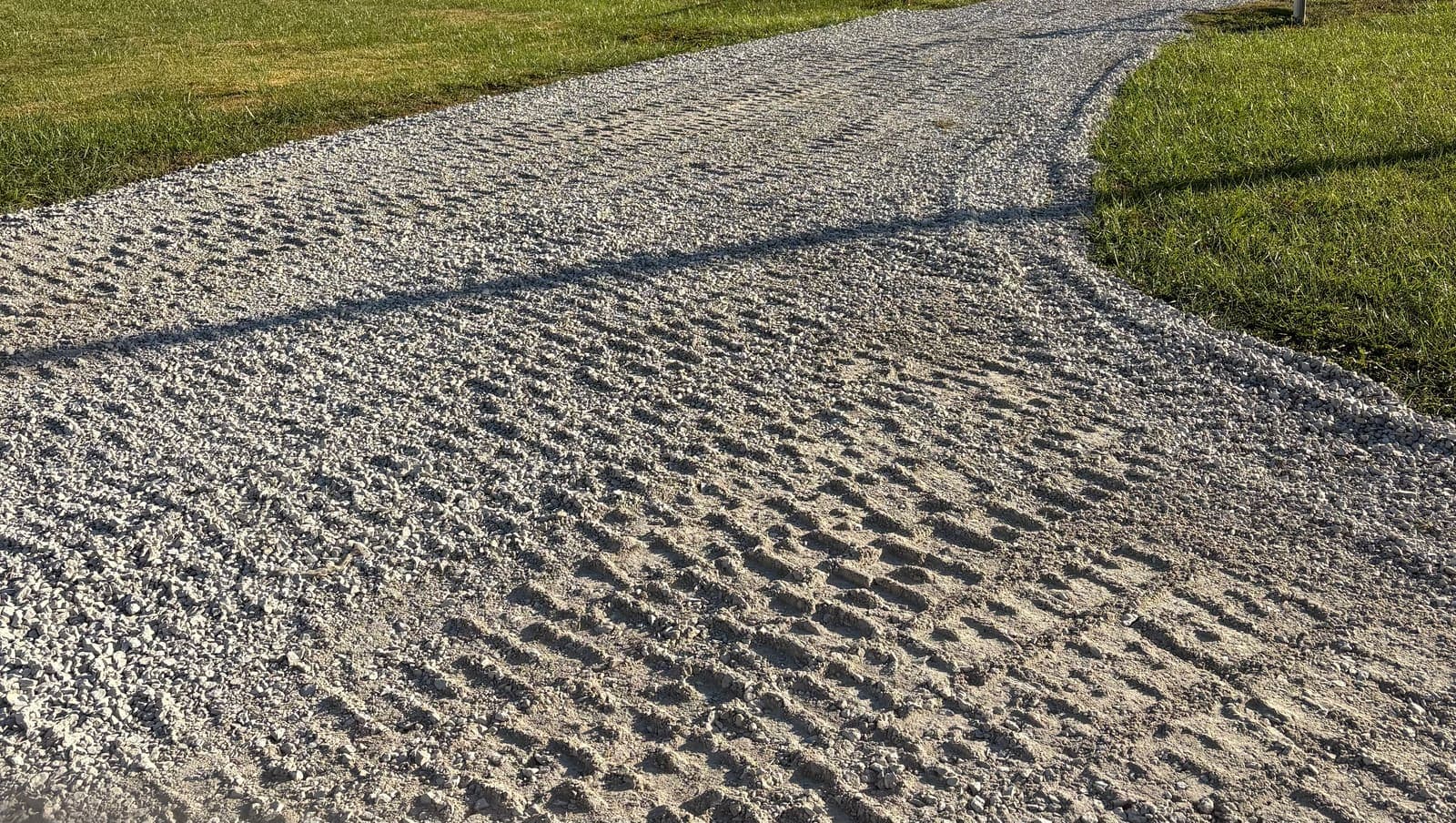 Close-up of a freshly compacted gravel driveway in evening light